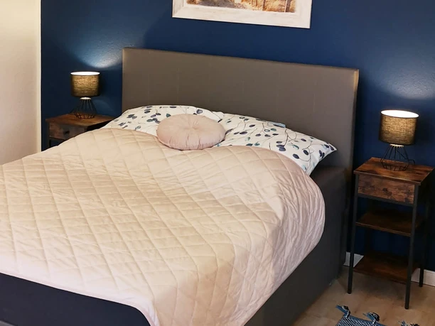 Schlafzimmer mit Doppelbett und Bild darüber