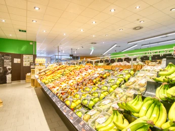 Auswahl Obst Eine breite Auswahl an frischem Obst, darunter Bananen, Äpfel und Birnen, in einem hell beleuchteten Supermarkt.