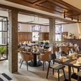 Restaurant Hotel WunnersWat.jpg Gemütliches Restaurant mit eleganter Holzausstattung, gedeckten Tischen und gemütlicher Atmosphäre.