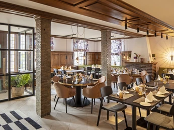 Restaurant Hotel WunnersWat.jpg Gemütliches Restaurant mit eleganter Holzausstattung, gedeckten Tischen und gemütlicher Atmosphäre.