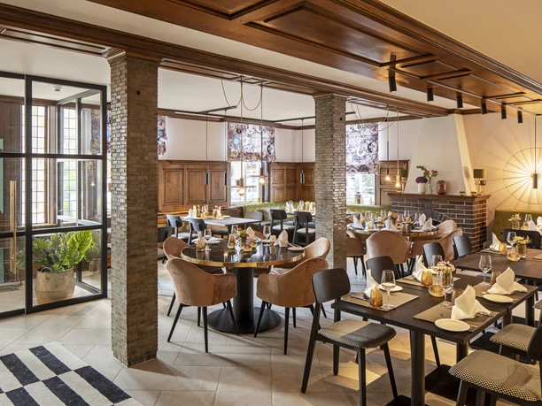 Restaurant Hotel WunnersWat.jpg Gemütliches Restaurant mit eleganter Holzausstattung, gedeckten Tischen und gemütlicher Atmosphäre.