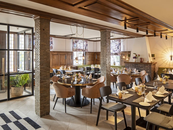 Restaurant Hotel WunnersWat.jpg Gemütliches Restaurant mit eleganter Holzausstattung, gedeckten Tischen und gemütlicher Atmosphäre.