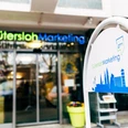 Eingangsbereich von Gütersloh Marketing mit modernem Logo und stilisierter Stadt-Silhouette auf Schild.