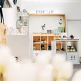 Ein heller Pop-up-Store mit Regalen voller dekorativer Produkte und Accessoires.