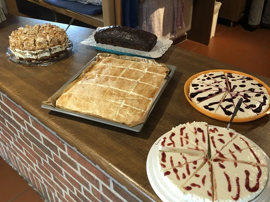 Kloencafe1.JPG Eine Auswahl an köstlichen Kuchen, liebevoll auf einem rustikalen Tresen im Café arrangiert.