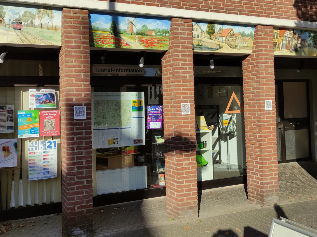 Tourist-Information Vlotho Die Tourist-Information in Vlotho. Die Fassade ist aus Backsteinen und teilweise mit kleinen detailreichen Bildern von alten Häusern bemalt.