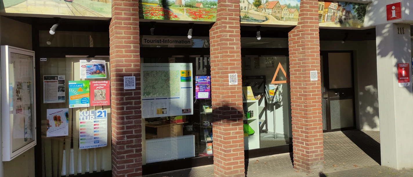 Tourist-Information Vlotho Die Tourist-Information in Vlotho. Die Fassade ist aus Backsteinen und teilweise mit kleinen detailreichen Bildern von alten Häusern bemalt.