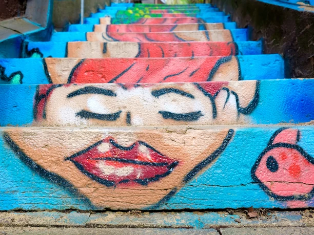 Eine Meerjungfrau mit roten Haaren und roten Lippen auf die einzelnen Stufen einer Treppe gemalt