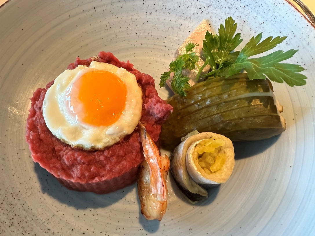 Labskaus Labskaus mit Spiegelei, Gewürzgurke und Rollmops auf Keramikteller, appetitlich angerichtet.