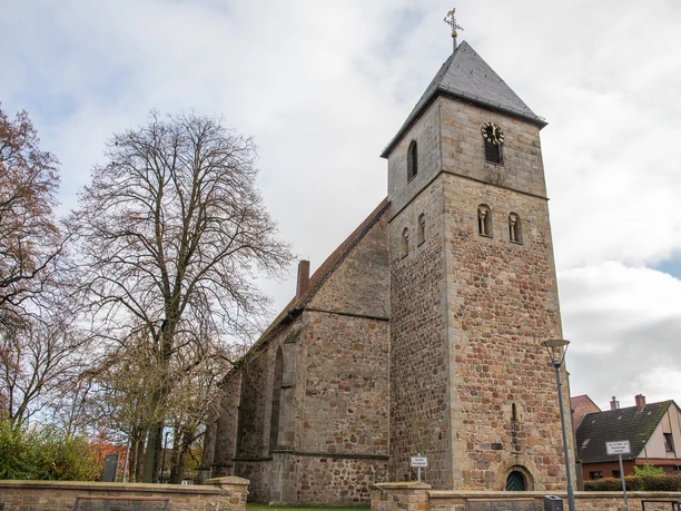 Ev.-ref. Kirche in Lengerich Historische Kirche aus Sandstein mit Turm und spitzem Dach, umgeben von Bäumen und Häusern.