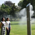 2016-09-01_Nebelsäule.JPG Menschen stehen in einem Park vor einer Nebelskulptur aus Metall, die Wassernebel sprüht.