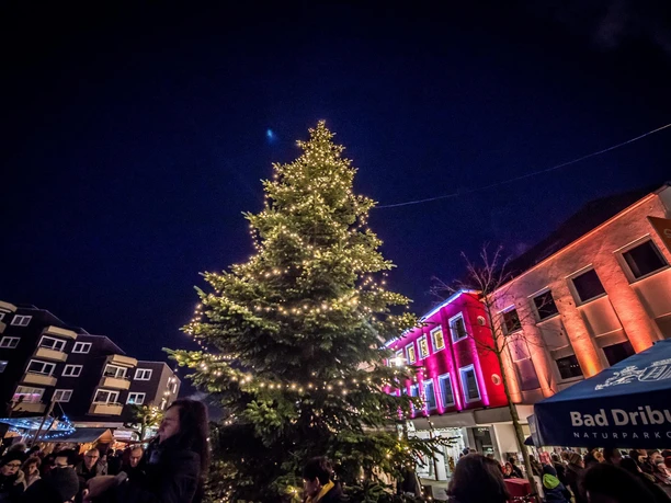 Adventsmarkt in Bad Driburg mit beleuchtetem Tannenbaum in der Mitte.