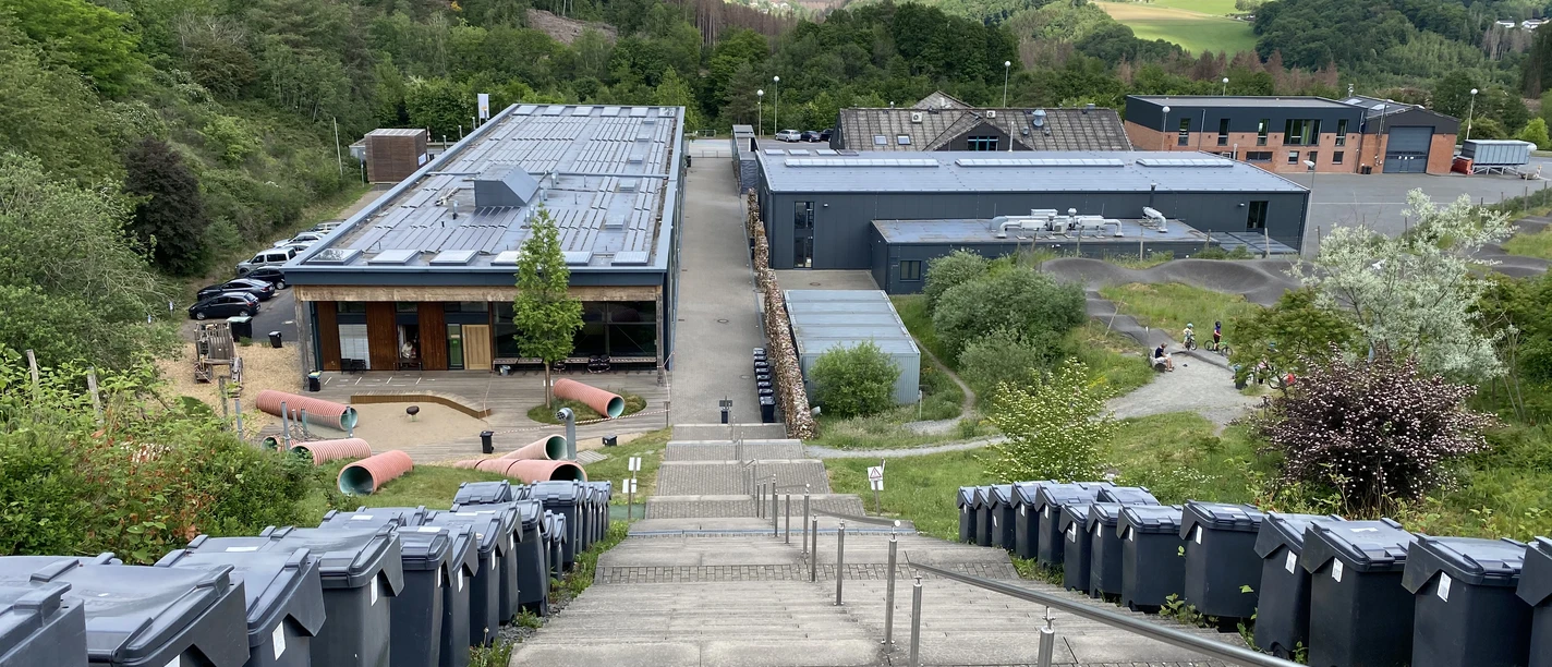 :metabolon Industriemuseum in grüner Umgebung mit Blick auf Lindlar. Innovativ gestaltete Gebäude und Gelände.