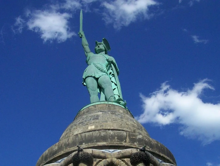 Blick auf das Hermannsdenkmal im Teutoburger Wald, mit erhobenem Schwert vor blauem Himmel.