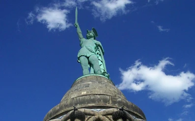 Hermannsdenkmal_Teutoburger Wald Tourismus_Bohlken_1600.jpg Blick auf das Hermannsdenkmal im Teutoburger Wald, mit erhobenem Schwert vor blauem Himmel.