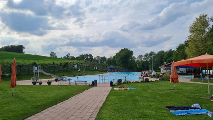 Die Wiese und zwei Schwimmbecken des Waldfreibads Vlotho.