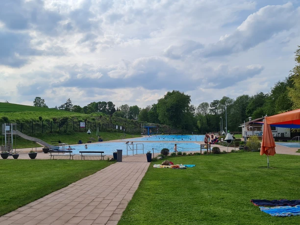Die Wiese und zwei Schwimmbecken des Waldfreibads Vlotho.