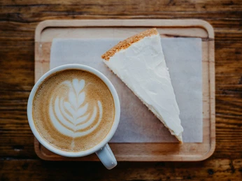 Das Bild zeigt ein Stück Kuchen und eine Tasse Kaffee.