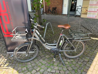 Ein modernes Pedelec steht auf einem gepflasterten Platz, bereit zur Ausleihe, ideal für Radtouren.