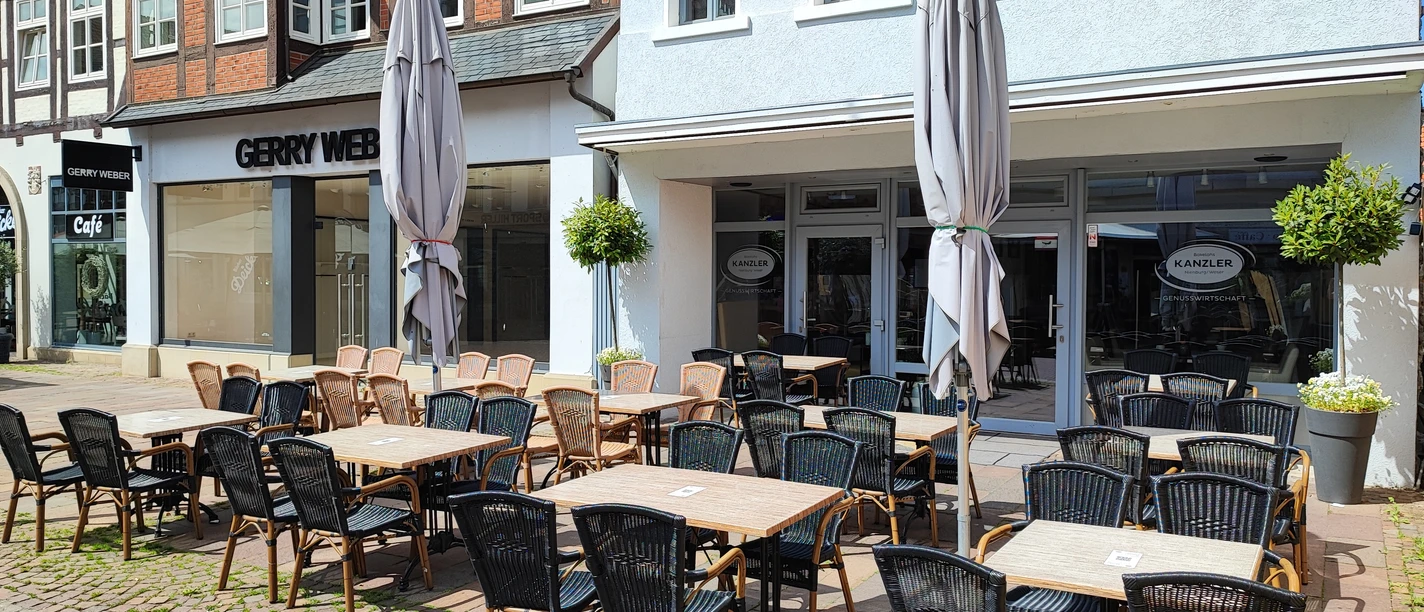 Inviting outdoor area of a café in a paved, sunny pedestrian zone.