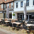 Genusswirtschaft Einladender Außenbereich eines Cafés in einer gepflasterten, sonnigen Fußgängerzone.Inviting outdoor area of a café in a paved, sunny pedestrian zone.Indbydende udendørs område på en café i en brolagt, solrig gågade.Uitnodigende buitenruimte van een café in een verharde, zonnige voetgangerszone.