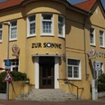Hotel zur Sonne Gelbes Gebäude des Hotel zur Sonne mit roten Dächern und seitlichen Treppen.