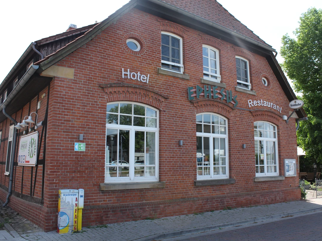 Restaurant Ephesus am Weserwehr Rotes Backsteingebäude mit großen Fenstern. Aufschrift "Ephesus" und Hinweis auf Hotel und Restaurant.