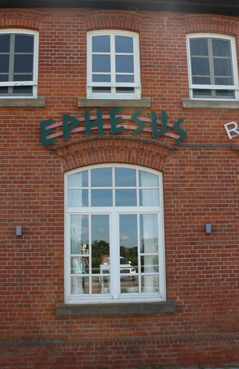 Historisches Backsteingebäude mit großen, weißen Fenstern, Schriftzug "Ephesus", am Weserwehr.