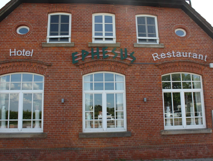 Historisches Backsteingebäude mit großen, weißen Fenstern, Schriftzug "Ephesus", am Weserwehr.Historic brick building with large white windows, "Ephesus" lettering, on the Weser weir.Historisk murstensbygning med store hvide vinduer, "Ephesus"-bogstaver, ved Weser-dæmningen.Historisch bakstenen gebouw met grote witte ramen, "Efeze"-belettering, aan de stuw van de Weser.