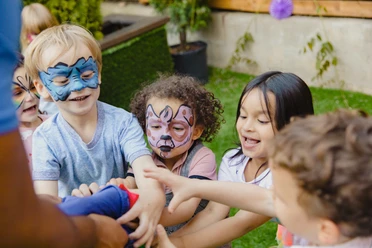 Bad Driburg - Kinderschminken - pexels Kinder mit bunten Gesichtsbemalungen lachen und spielen fröhlich im Freien bei strahlendem Wetter.