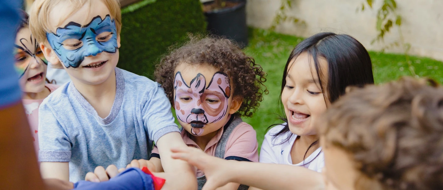 Bad Driburg - Kinderschminken - pexels Kinder mit bunten Gesichtsbemalungen lachen und spielen fröhlich im Freien bei strahlendem Wetter.