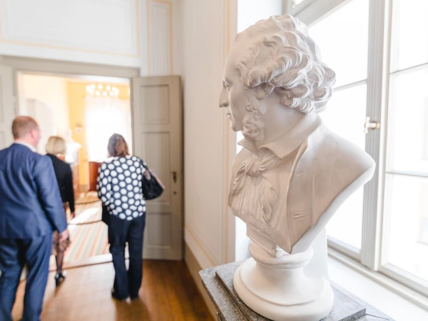 Bust of Felix Mendelssohn Bartholdy in the foreground, in the background guests on a tour of the exhibition in the Mendelssohn House, Leipzig - City of Music, Museums, Culture