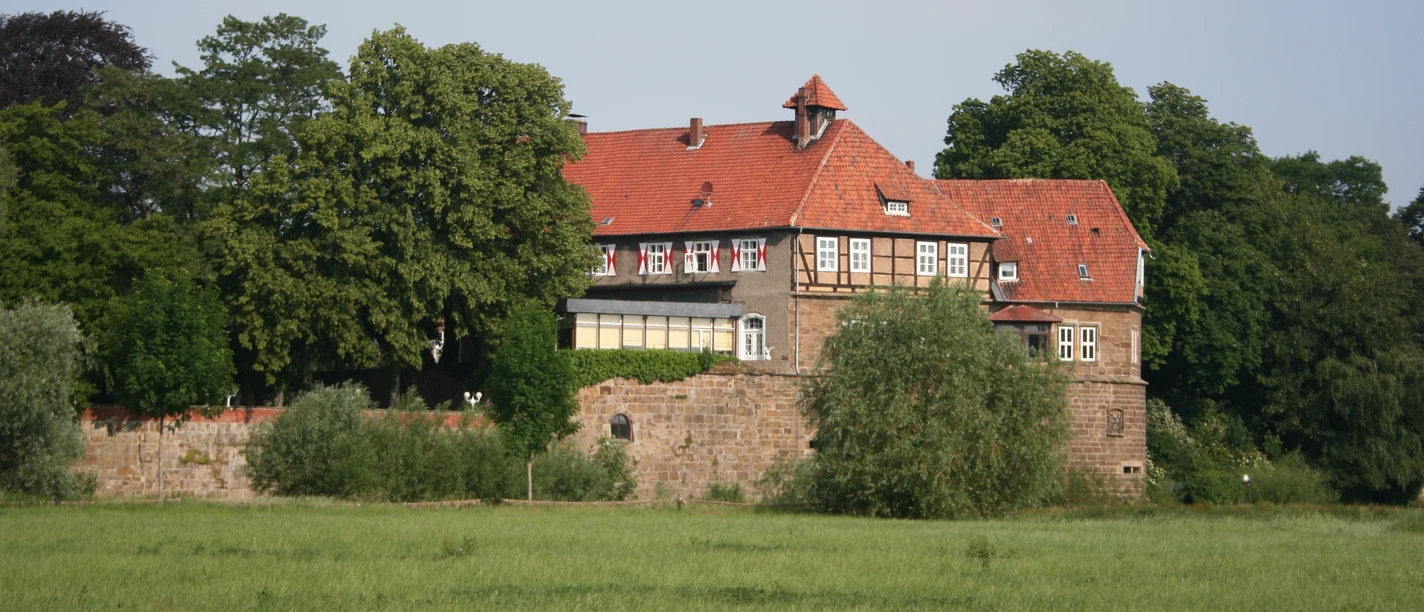 Schloss Petershagen Schloss Petershagen thront eindrucksvoll vor sattem Grün, umgeben von hohen Bäumen und Wiesen.