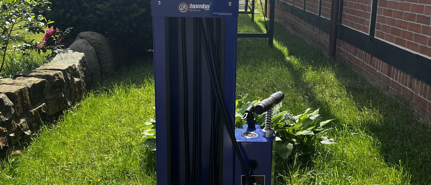 Fahrrad-Reparaturstation in Mardorf, umgeben von grünem Rasen, neben einem Fachwerkhaus platziert.