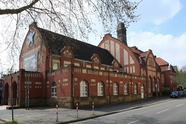 Kultur-Bahnhof Bochum-Langendreer Altes rotes Backsteingebäude mit gemusterten Ziegeln, großen Fenstern und einem hohen Schornstein.