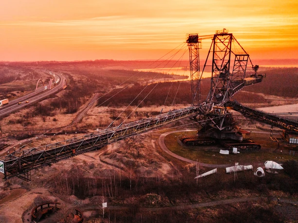 Vyřazené důlní stroje v Hornickém technologickém parku v Lipsku při západu slunce, průmyslová kultura, skanzen, exkurze