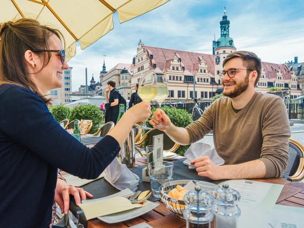 A young couple sits on the terrace of the Weinstock restaurant on Leipzig's market square and enjoys good food and delicious wine, Leisure, Gastronomy, Cuisine