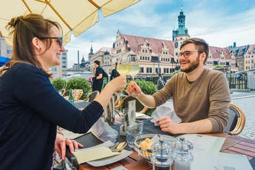Un jeune couple est assis à la terrasse du restaurant Weinstock, sur la place du marché de Leipzig, et savoure une cuisine raffinée et un vin délicieux : loisirs, gastronomie, cuisine.