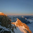 Zugspitzgipfel Verschneiter Gipfel der Zugspitze bei Sonnenuntergang mit schneebedeckten Bergen im Hintergrund.