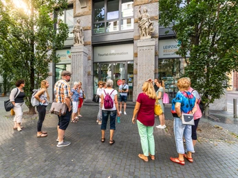 Tourist-Information Leipzig - Serviceeinrichtungen in Leipzig Eine Gruppe von Touristen steht vor dem Eingang der Tourist-Information Leipzig und erhalten eine Führung, Ausflug, Kurzurlaub