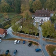 Luftaufnahme des historischen Mallinckrodthofs, umgeben von Bäumen, Gartenanlagen und Parkplätzen.