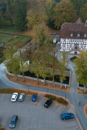 Luftaufnahme des historischen Mallinckrodthofs, umgeben von Bäumen, Gartenanlagen und Parkplätzen.