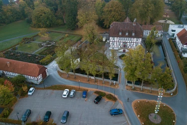 Mallinckrodthof von oben.jpg Luftaufnahme des historischen Mallinckrodthofs, umgeben von Bäumen, Gartenanlagen und Parkplätzen.