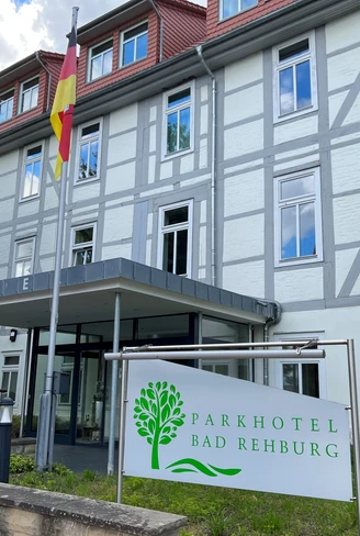 Das moderne Parkhotel Bad Rehburg in einem historischen Gebäude mit Fachwerk und deutscher Flagge.
