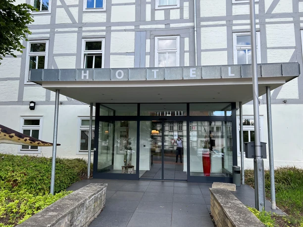 Entrance to a modern hotel with wide entrances, large glass surfaces and clearly visible lettering.