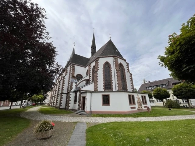 Martinskirche.jpg Martinskirche mit markanten gotischen Bögen und Türmen, umgeben von gepflegtem Grün und Wegen.
