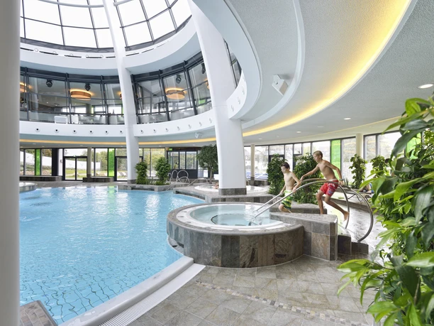 carpesol SPA Therme Spacious indoor pool with children's area, wrap-around balconies and natural light from the glass roof.