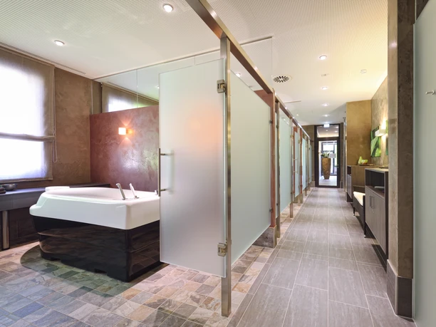 SPA-Bereich Moderne badkamer met vloertegels, ligbad en discrete lichtaccenten.