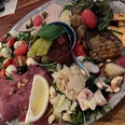 Antipasti Eine bunte Platte mit verschiedenen Antipasti, darunter Oliven, Salami, Tomaten und Käse.