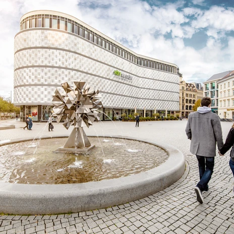 Widok na centrum handlowe Höfe am Brühl z Richard-Wagner-Platz z fontanną na pierwszym planie, rozrywka, zakupy, krótki odpoczynek